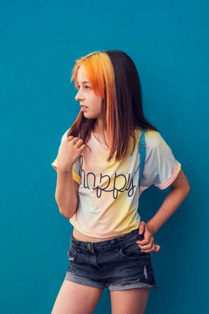 Girl portrait. A child outside in daylight during the day. Beautiful girl of school age with fashionable hair coloring. Positive portrait. A subtle girl with dyed bangs. Girl 9-11 years oldの写真素材