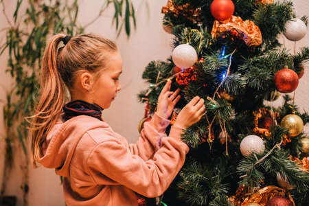 child little girl near christmas tree at home. Christmas teenager girl christmas tree.の写真素材