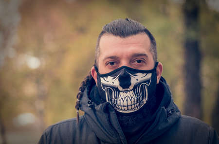 man in winter clothes on the street with a medical face mask on.の写真素材