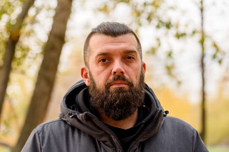 Man with a beard in a gray jacket on the street. Portrait of a man. The guy with the beard.の写真素材