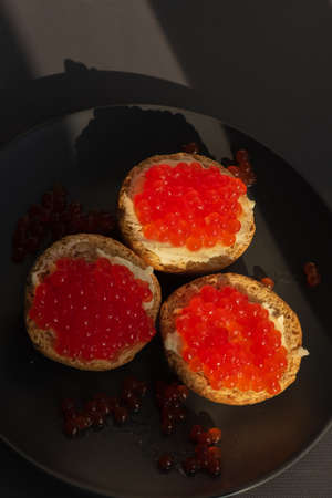 Sandwich with caviar. Celebratory snack. Sandwich with butter and red caviar