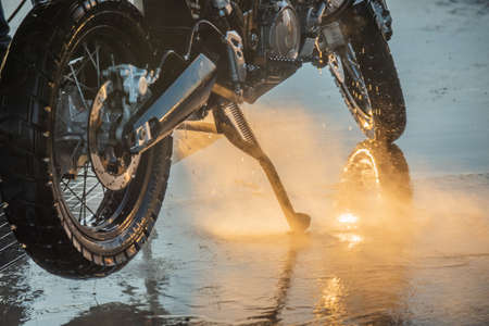 Motorbike washing series. Washing a motorcycle at a car wash at sunsetの写真素材
