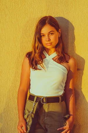 Portrait of Hipster Girl on Yellow Wall Background. Urban Fashion Concept. Teenage girl