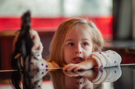 Child girl playing toy horse indoors. Childhood child toys. Cute little girl