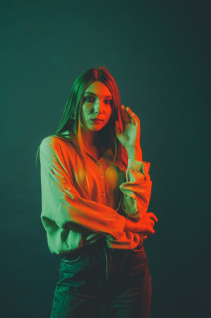 Creative portrait of a beautiful female model close-up. orange and green lighting in the Studio.