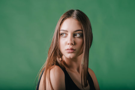 portrait of a beautiful girl on green background. Brunette girl on green background