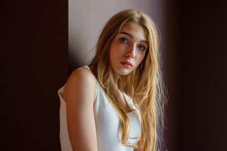 Lifestyle concept. Girl in a cafe with brown hair and in a white dress. Portrait.の写真素材