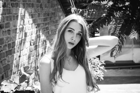 Portrait of beautiful stylish girl walking down the street. Girl in a white dress in the summer.