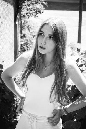 Portrait of beautiful stylish girl walking down the street. Girl in a white dress in the summer.の写真素材