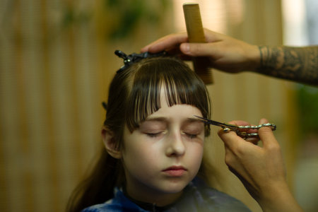 Little girl gets her bangs cut at beauty salon. Beauty conceptの写真素材