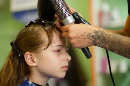 Little girl gets her bangs cut at beauty salon. Beauty conceptの写真素材