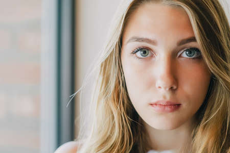 Portrait of a young woman with beautiful hair and gray eyes. Close-up portrait of a blonde girl.の写真素材