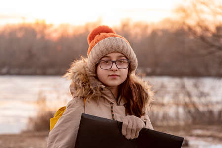 Portrait of teenager girl with school backpack holding folders. girl with folder and backpackの写真素材