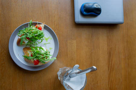 Healthy sandwich on office table. Laptop on the table and a sandwich. Computer and foodの写真素材
