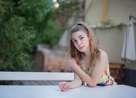 girl in dress walks through the old town in the summer. Beautiful blonde woman summer photo.の写真素材