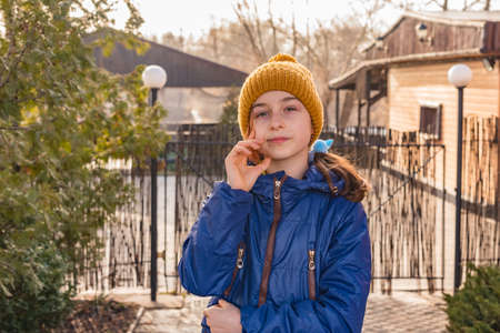 girl in a blue jacket winter. Girl in a blue jacket for a walk. Portrait of a teenager in a jacket and hatの写真素材