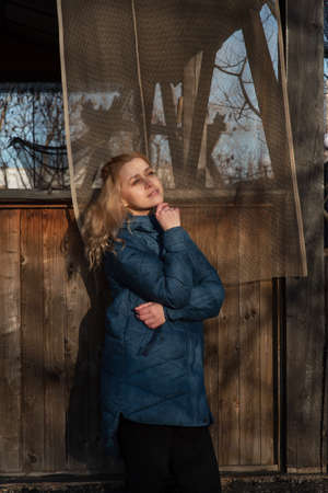 Woman in blue jacket on the street. Thought woman thoughtfulness. Woman holding chin with her handの写真素材