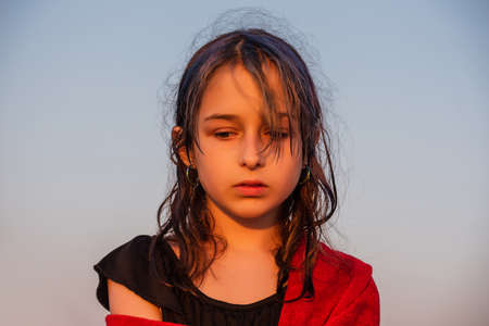 Girl in a red towel at the sea. Teenager girl at the sea. Rest, vacation. at sunset by the sea.の写真素材
