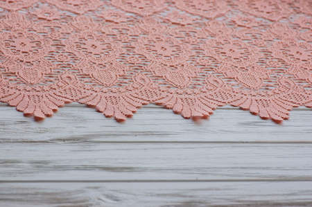 knitted lace. The material is folded randomly on a horizontal surface. Sample of fabric. Beige lace