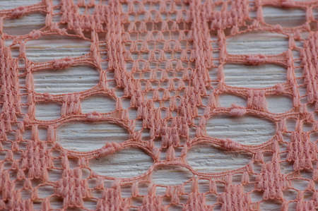 knitted lace. The material is folded randomly on a horizontal surface. Sample of fabric. Beige lace