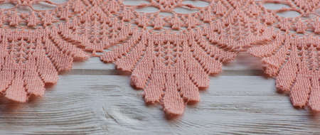 knitted lace. The material is folded randomly on a horizontal surface. Sample of fabric. Beige lace