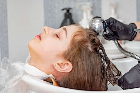 Teenage girl in a beauty salon on hair coloring and a haircut. Beauty concept. child, hairdressing,の写真素材