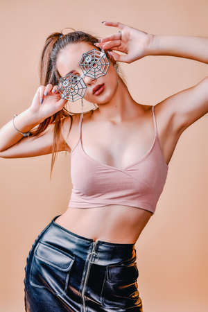 A girl of 18-20 years old wore glasses with a spider design for Halloween or a theme party.
