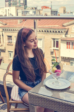 Teen girl happy smiling sitting in restaurant or cafe and eating ice cream. food dessert girl cafeの写真素材