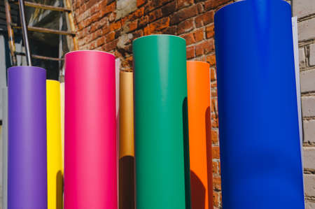 Row of various colored vinyl car wrapping or plotter cutting sticker foil film rolls, plot, sticker,の写真素材
