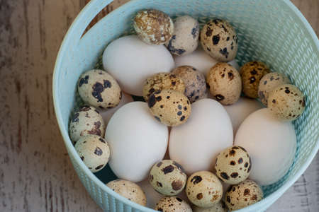 Lots of white chicken eggs and quail eggs in a plastic basket. selective focusの写真素材