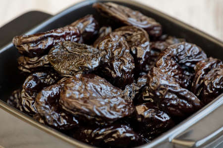 prunes group in wooden bowl. Dried prunes in a plate. plate, food, blackの写真素材