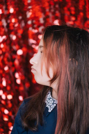 school girl. Schoolgirl on a red background portrait. A series of portraits of emotional girls.