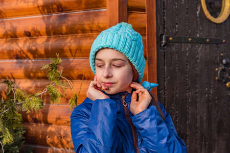 girl in a blue jacket winter. Girl in a blue jacket for a walk. Portrait of a teenager in a hat