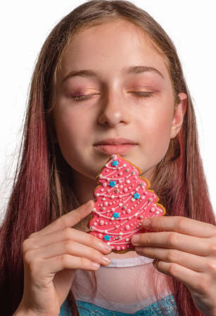 Girl and Christmas gingerbread in the form of a pink Christmas tree. Looking forward to christmas
