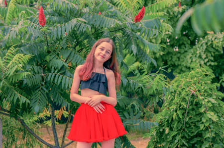 Young girl in a red skirt. Teenager girl summer portrait outdoor.の写真素材