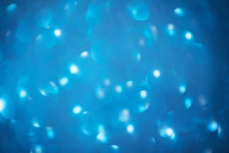 Defocused abstract blue christmas background. Blue glitter defocus light.