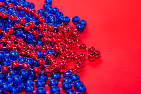 Christmas background. New Year. Beads in red and blue on a red background.の写真素材