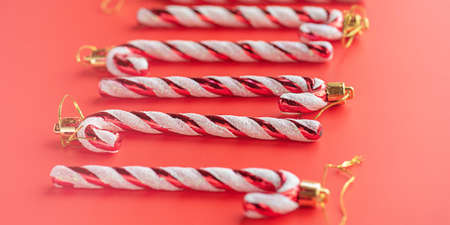 New Year's toys in form of white lollipops in red stripes on a red background. Christmas ornament.の写真素材