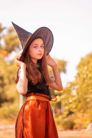 Little girl in Halloween costume, autumn. Girl 11 years old against the background of autumn nature.の写真素材