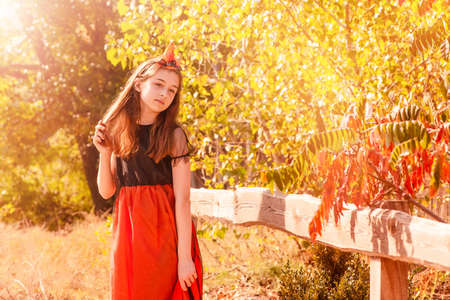 Autumnal portrait of a little girl 11 years old in a pumpkin costume for Halloween. October Novemberの写真素材