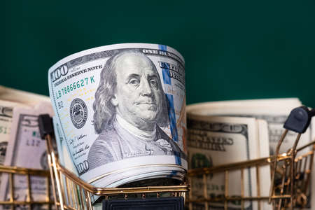Finance, banks. Three shopping carts with paper banknotes on a dark green background.の写真素材