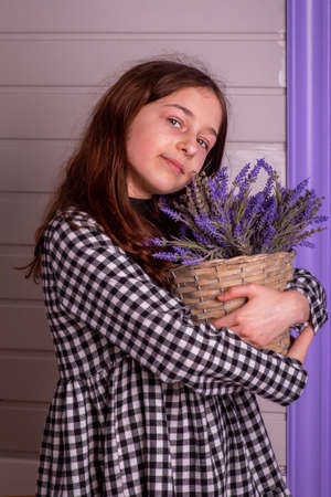 Portrait of a 10 year old girl. Teenage girl with lavender flowers in her hands.の写真素材