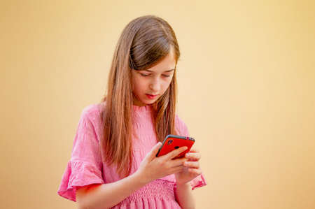 Girl with a smartphone in her hands. A teenage girl looks into her gadget.の写真素材