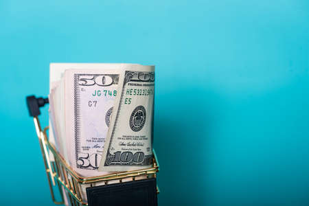 American dollars on a blue background. Finance, business and banking. American dollars in a cart.の写真素材