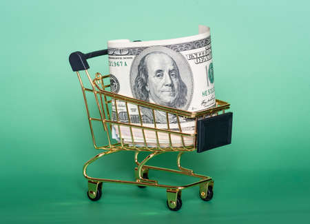 American dollars on a green background. Finance, business and banking. American dollars in a cart.の写真素材