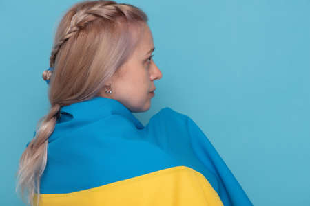 Portrait of a woman. Woman with blond hair with blue-yellow cloth on her shoulders.の写真素材