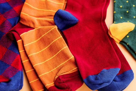 Brown green red socks macro photo. Socks of different colors on a beige background.