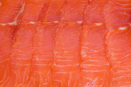 Red fish macro photo as background. Lightly salted salmon fillet cut into thin pieces.の写真素材