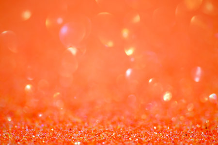 Glitter paper defocus as background. Orange. Sparkles defocus light.