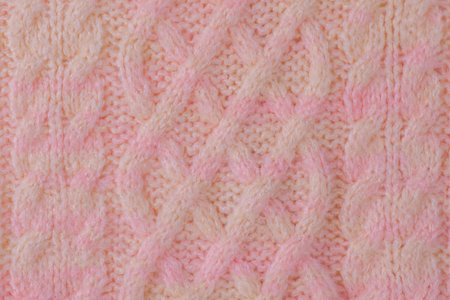 Terry knitted texture as a macro photo background. Pink and beige detail of a knitted item.